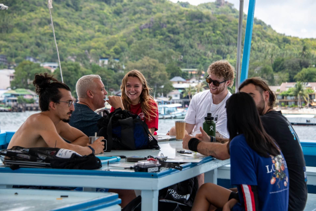 blackturtleconservation.com-advanced-ecological-monitoring-program-team-on-boat-koh-tao-thailand Marine conservation students from the Advanced Ecological Monitoring Program reviewing survey plans and data collection sheets onboard before dives in Koh Tao.