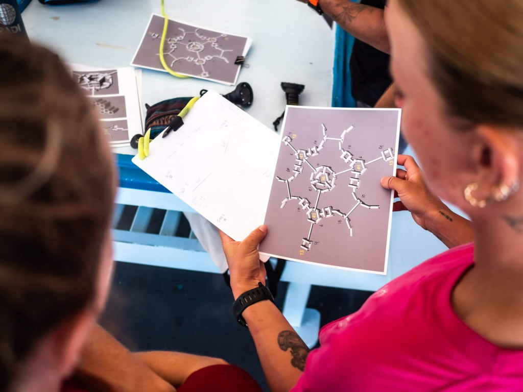 blackturtleconservation.com-artificial-reef-structure-planning-workshop-koh-tao Students reviewing artificial reef design plans during a conservation workshop at Black Turtle Conservation in Koh Tao.