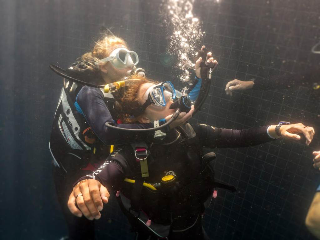 Rescue Diver student practicing underwater emergency response skills and regulator management in a controlled training environment in Koh Tao.