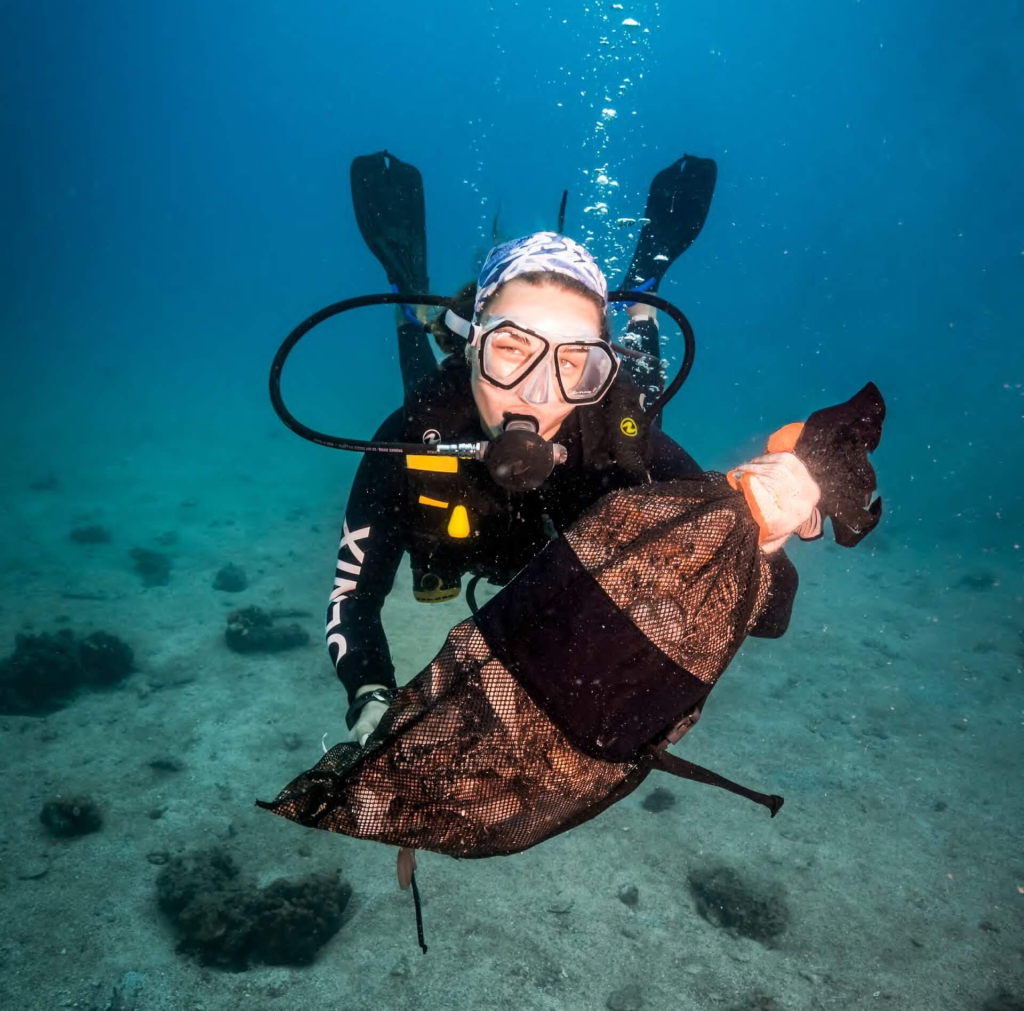 Marine conservation divers conducting an underwater survey to assess plastic and debris pollution around Koh Tao reefs.